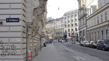 A street view with buildings, a gas canister on the sidewalk, and a sign reading "6. Chwalagasse".