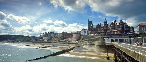 Un pueblo costero con edificios históricos, un muelle y un muro de contención.