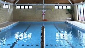 An indoor swimming pool with a wooden ceiling and brick walls. - The Links Country Park Hotel (Cromer)
