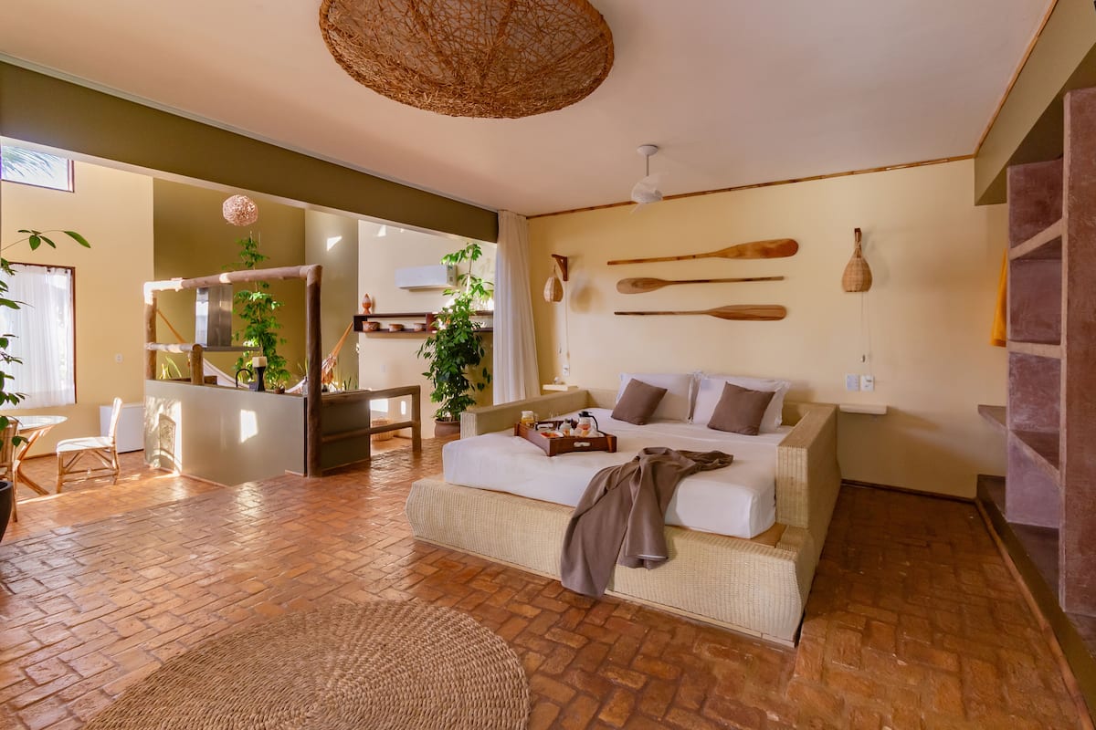 Una sala de estar acogedora con un sofá, un comedor con mesa y sillas, y una cocina al fondo.