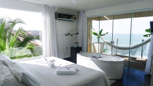 A bedroom with a bed, a bathtub, and a view of the ocean. - Kilombo Villas & Spa (Tibau do Sul)