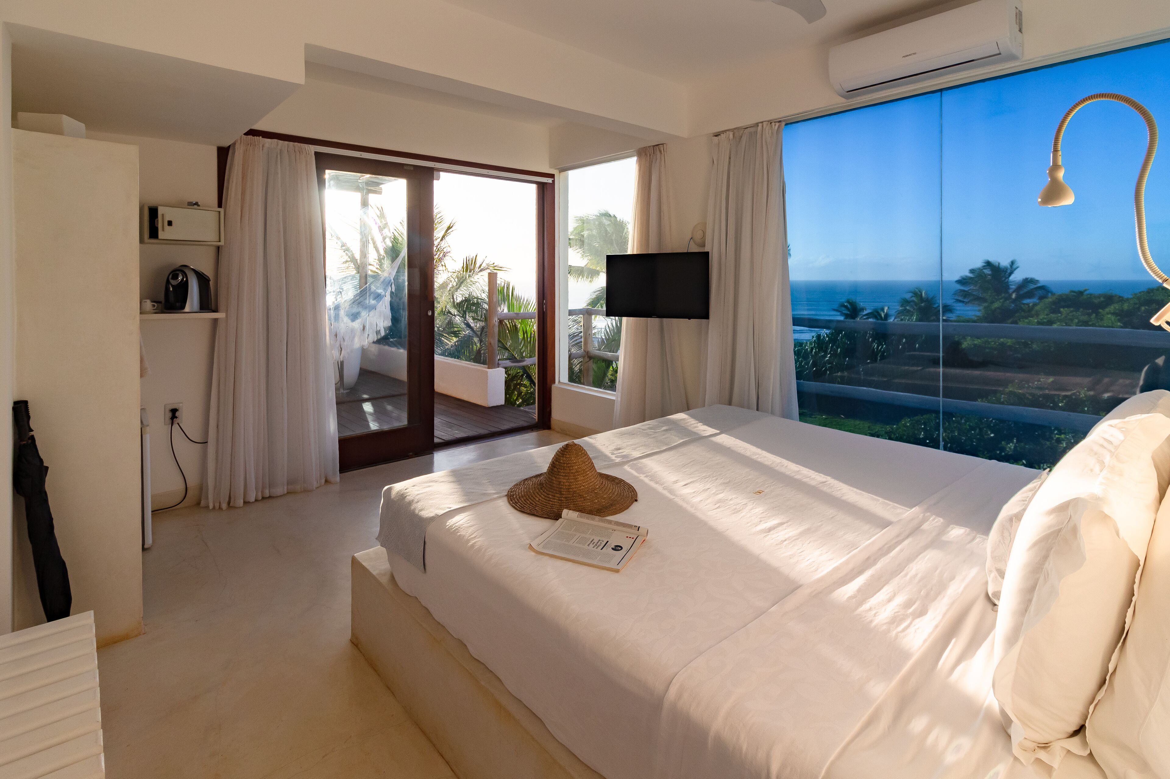 Une chambre avec un grand lit, une télévision et une vue sur l’océan.