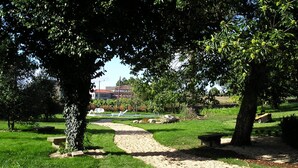 A park with a gravel path, benches, and trees. - Casa Grande da Capellanía (Padron)