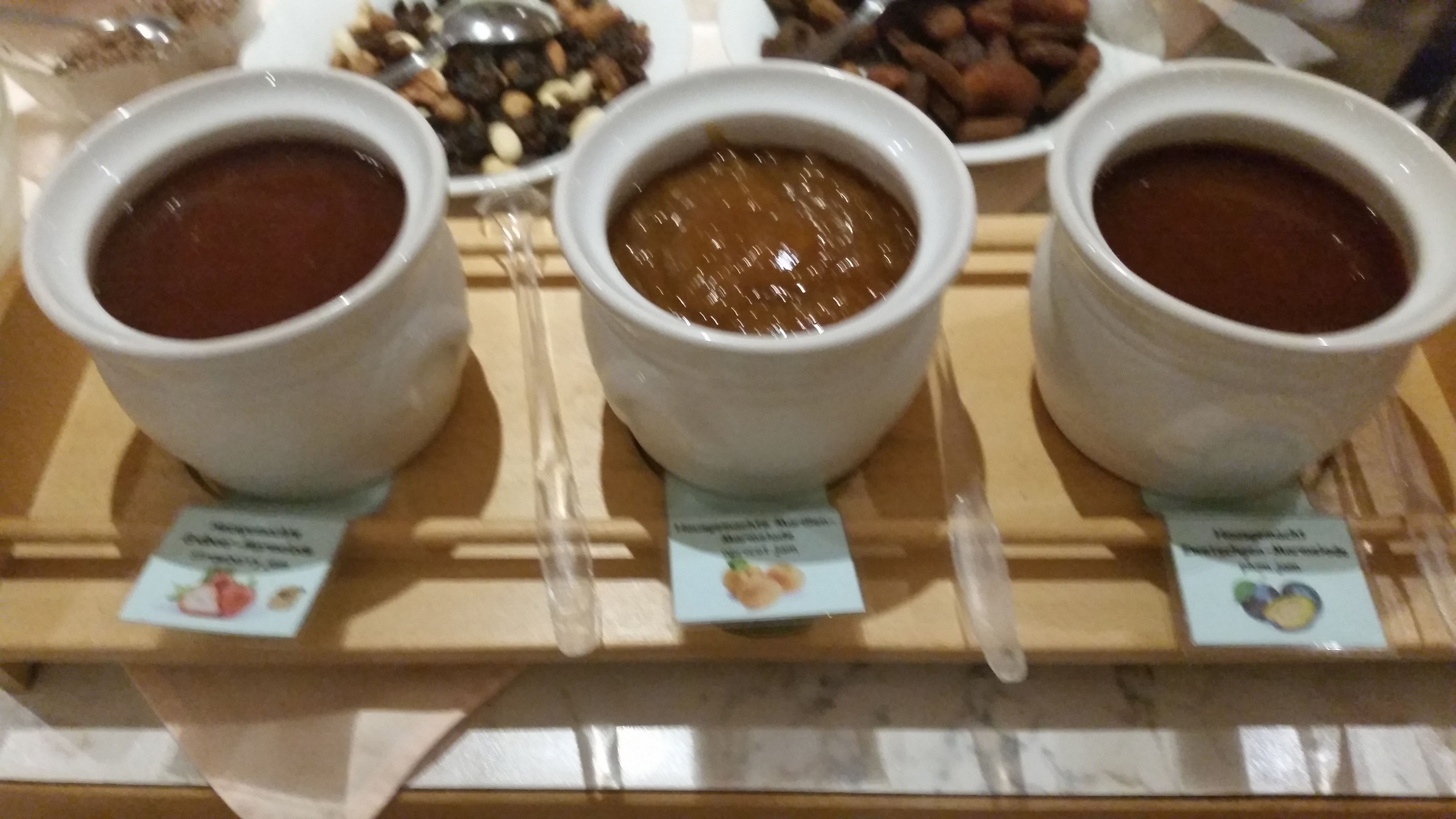 Trois bols de nourriture, chacun portant une étiquette, sont placés sur une planche en bois.