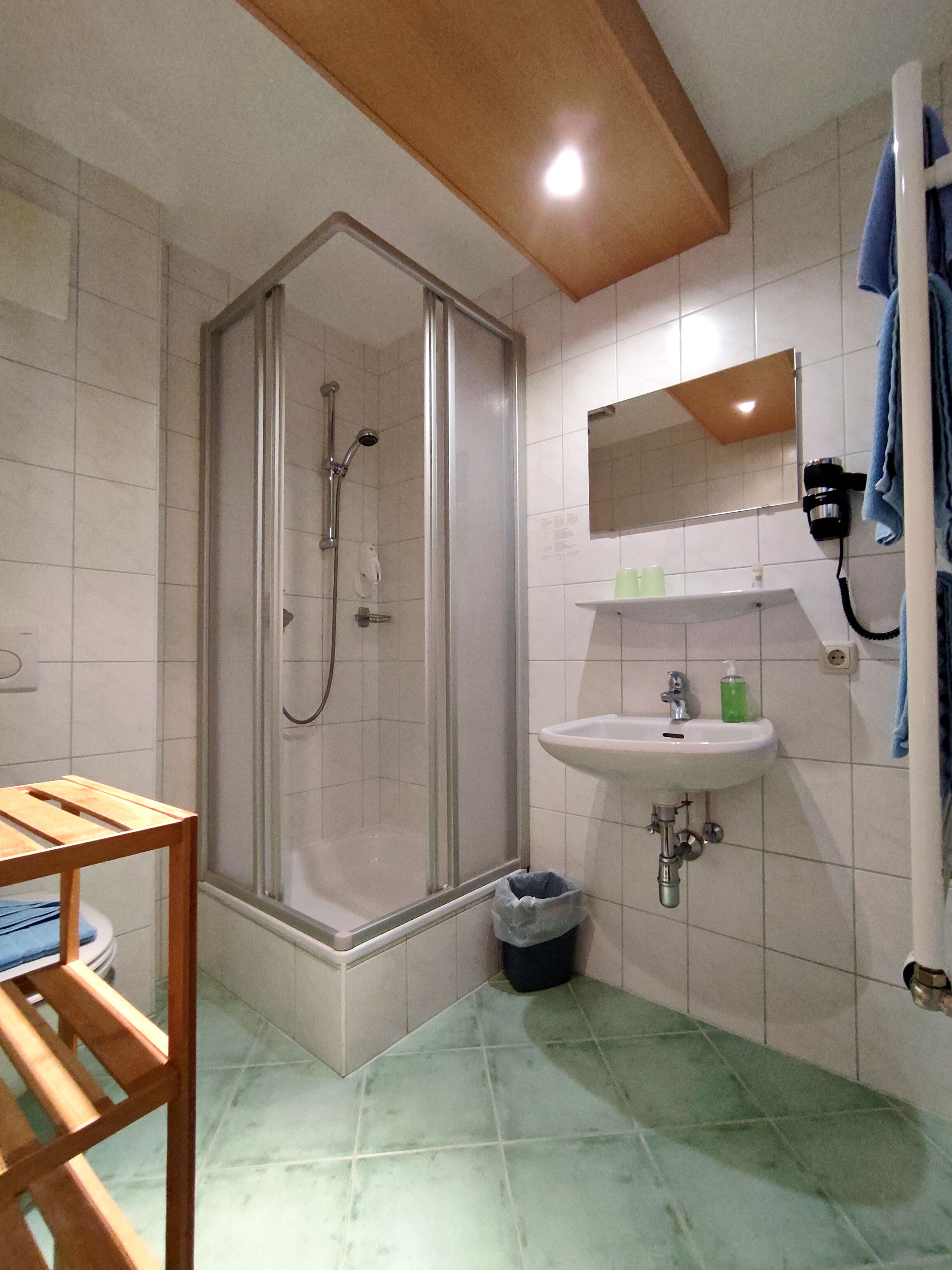 Un baño con ducha, lavabo y espejo.