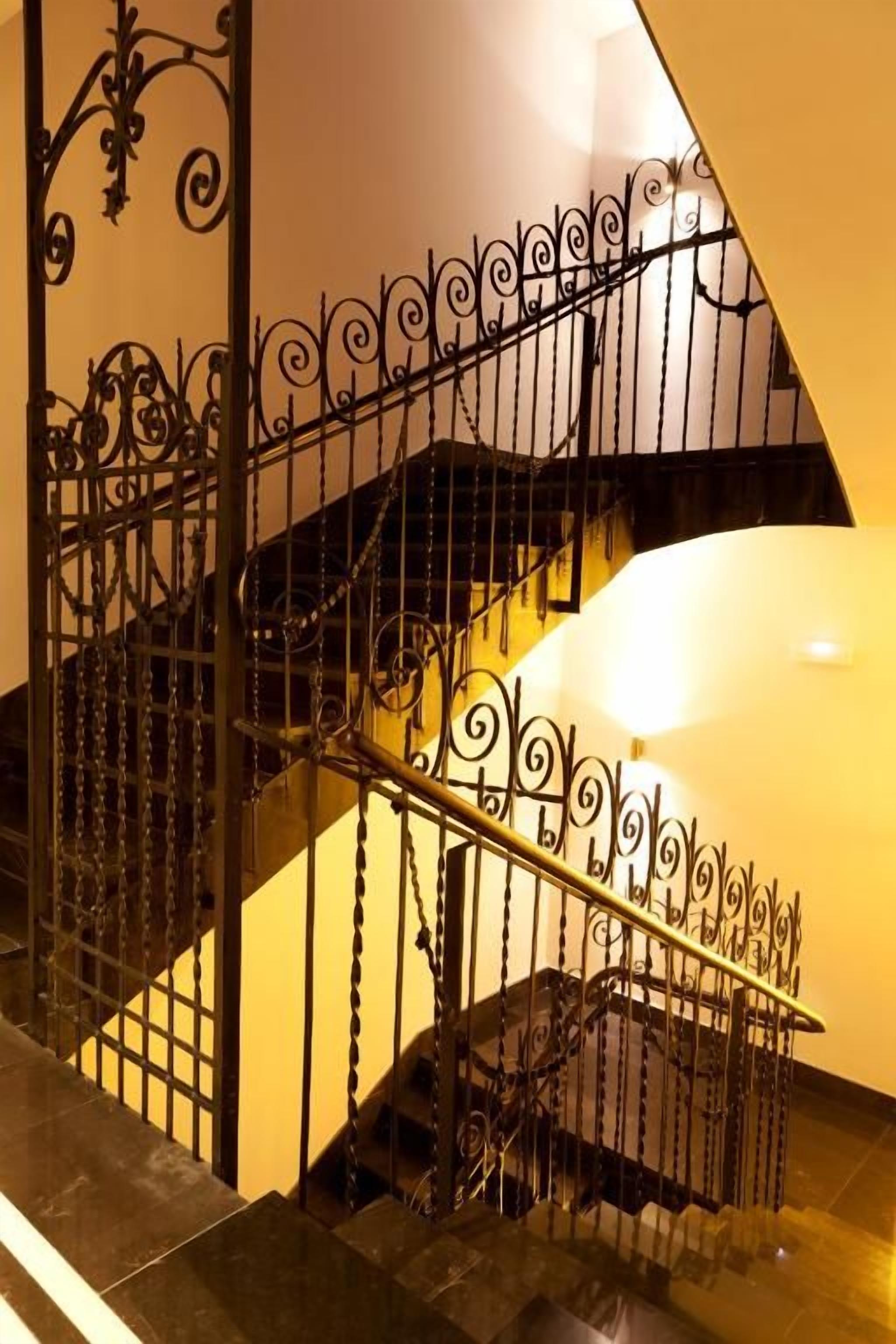 Una escalera con barandillas y pasamanos de metal decorativo.