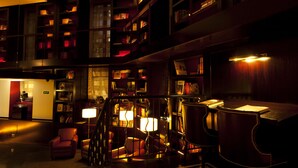 Une bibliothèque avec des étagères, un bureau et des fauteuils en cuir.