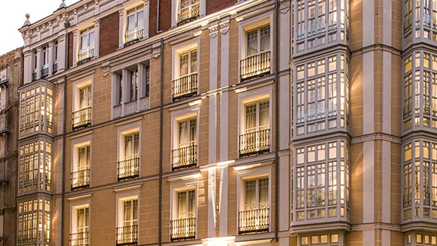 Un immeuble à étages, de style architectural classique, caractérisé par une façade symétrique avec des fenêtres et des balcons régulièrement espacés.