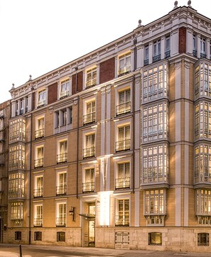 A multi-story building with a classic architectural style, featuring a symmetrical facade with evenly spaced windows and balconies. - Hotel Boutique Gareus (Valladolid)