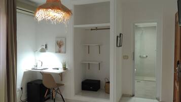 Un dormitorio moderno con escritorio, silla y lámpara colgante.