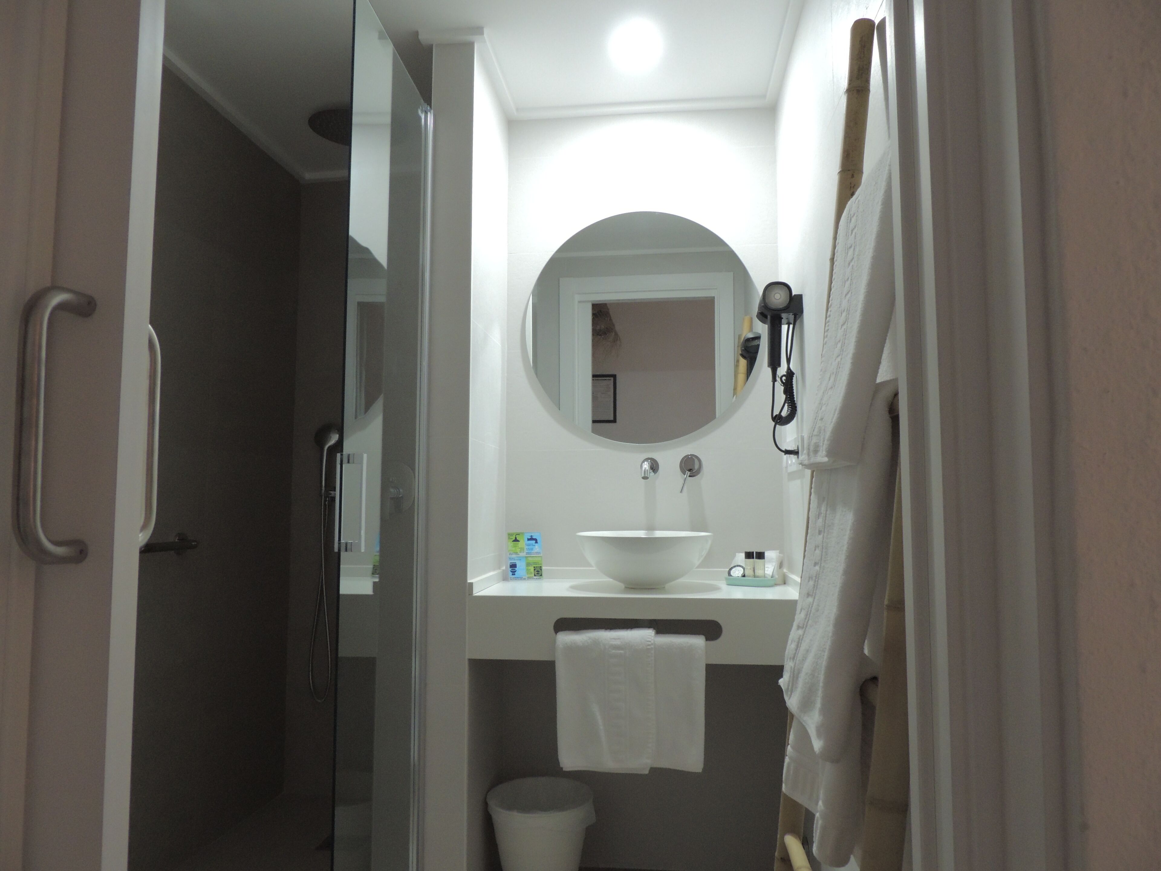 A bathroom with a white sink, a mirror, and a towel rack.
