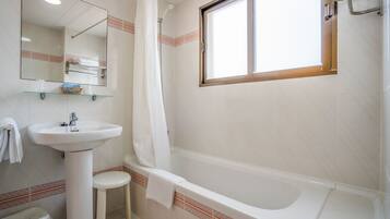 A bathroom with a sink, toilet, and bathtub.