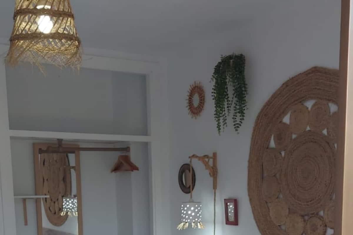 Un dormitorio con una cama grande, una lámpara colgante y un espejo.