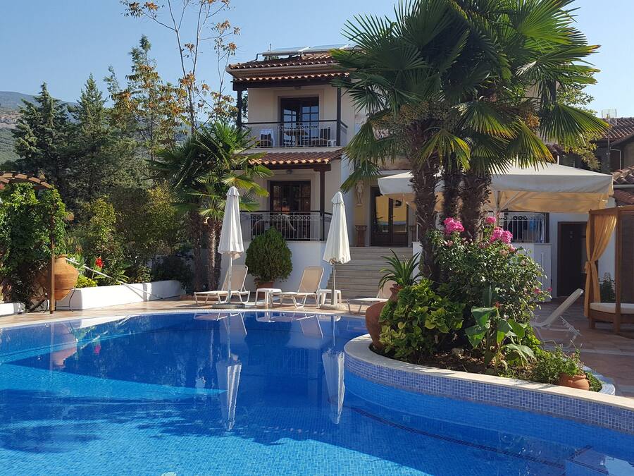 Una piscina al aire libre, sombrillas, tumbonas