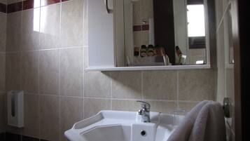 A bathroom with a sink, mirror, and toiletries.