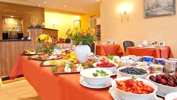 A breakfast buffet with a variety of fruits, pastries, and beverages on a table in a hotel room. - Landhotel Garni Engelhard (Kirchheim am Ries)