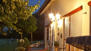 A patio with outdoor furniture, a barbecue grill, and a stone wall. - Landhotel Garni Engelhard (Kirchheim am Ries)