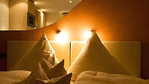 A hotel room with a curved wall and a large bed with multiple pillows. - Landhotel Garni Engelhard (Kirchheim am Ries)
