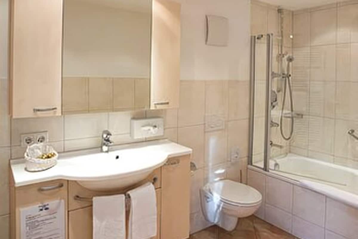 deep-soaking bathtub, hair dryer, slippers, towels