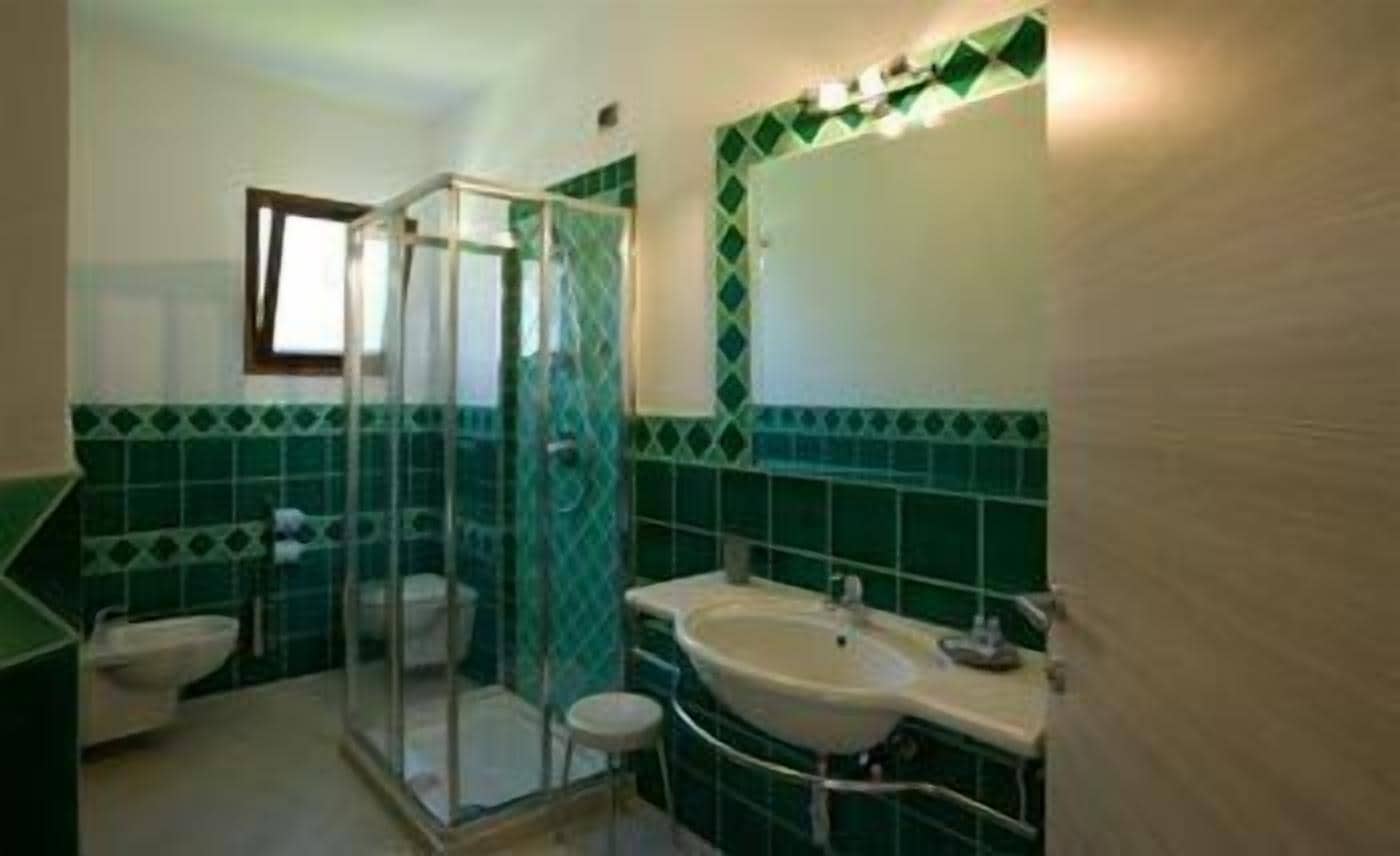 A bathroom with a shower, toilet, and sink.