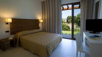 Ein Schlafzimmer mit einem großen Bett, einem Schreibtisch und einem Fernseher.