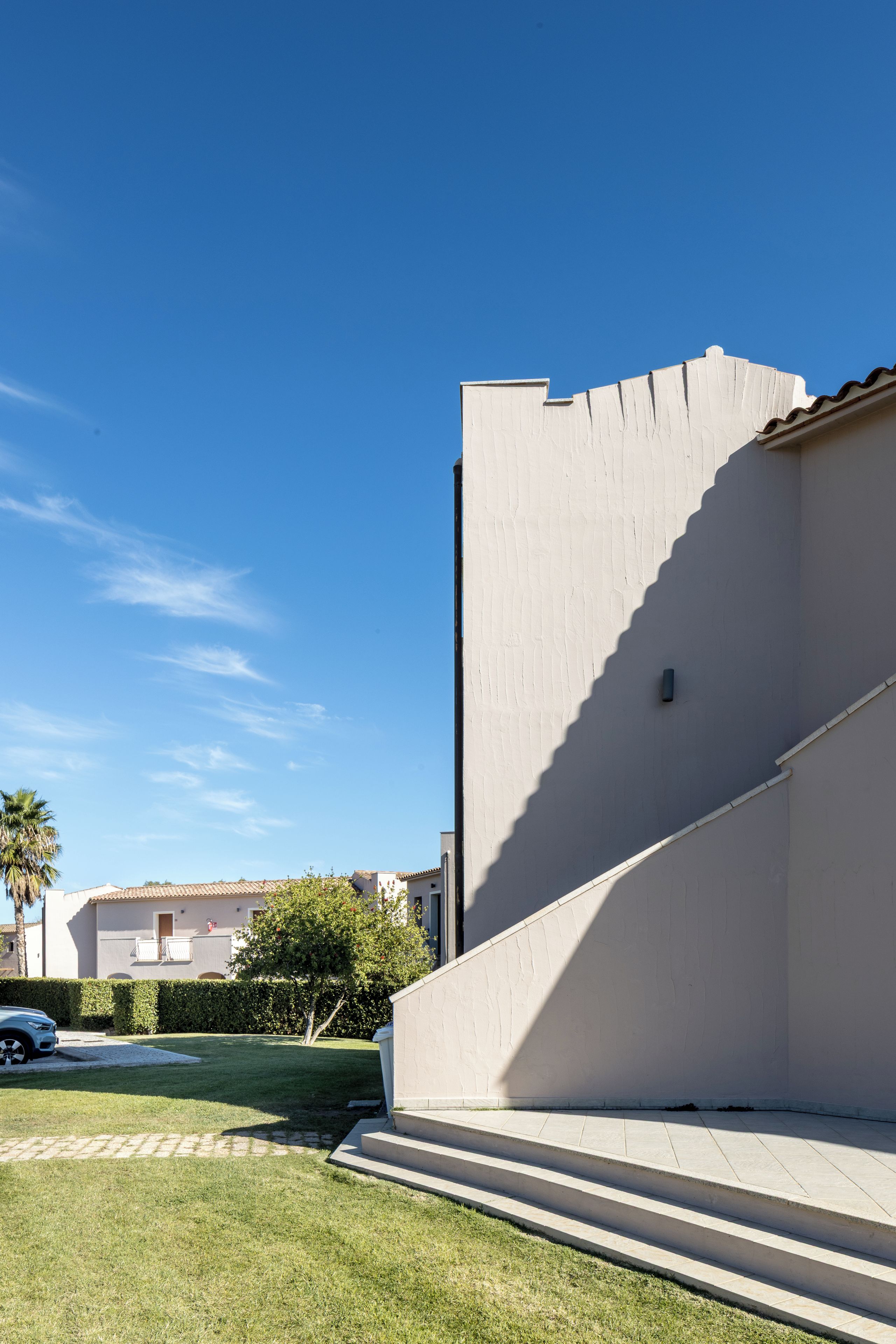 A building with a flat facade and a set of steps leading to a door.