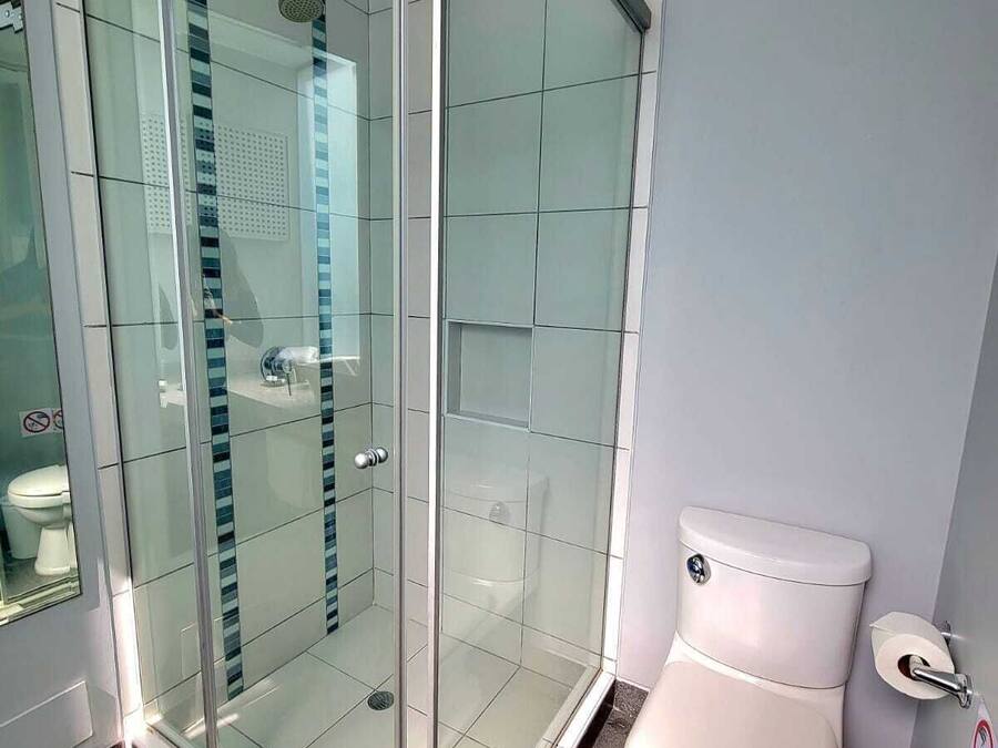 Un baño moderno con ducha envuelta en vidrio, inodoro y bidé.