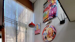 A modern living room with teal sofas, a red chair, and a staircase with a colorful mural. - Barranco Boutique Hotel by 3B  (Lima)