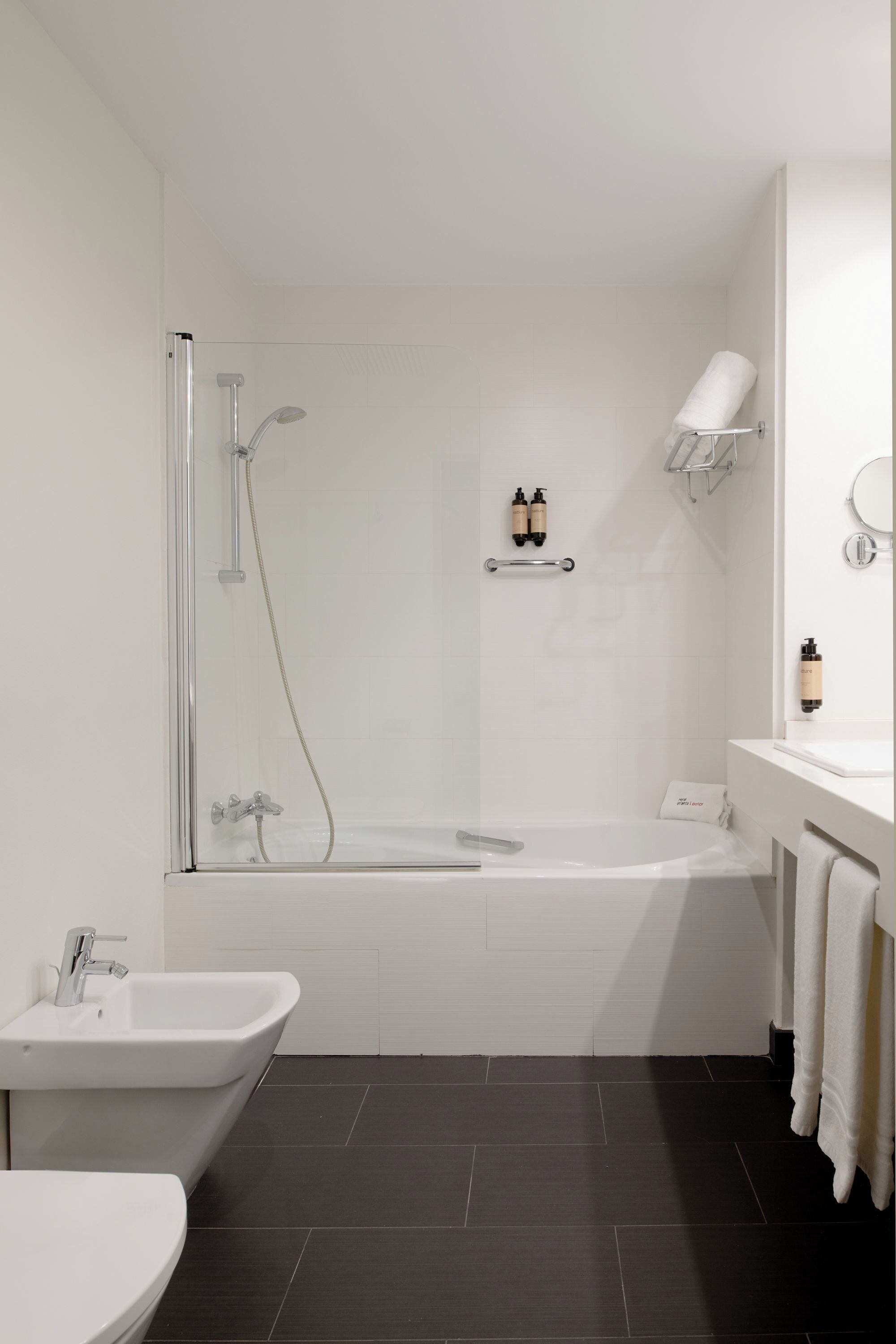 Un baño moderno con bañera, ducha, lavabo e inodoro.