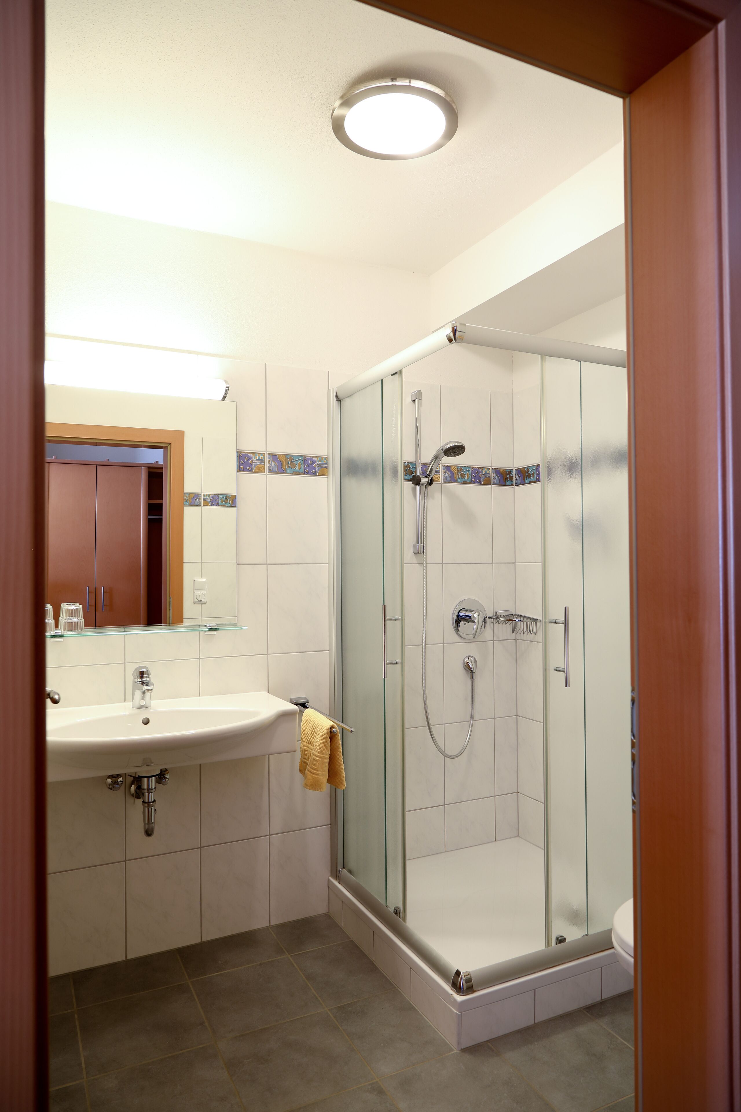 Ein Badezimmer mit Duschkabine, Waschbecken und Toilette.