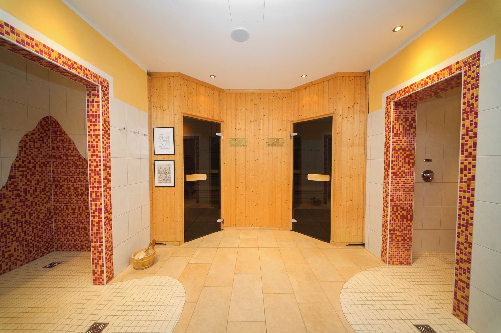 Un pasillo con paredes de madera y pisos de baldosas, que conduce a dos puertas.