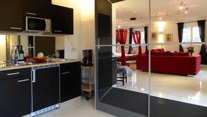 Una cocina moderna con microondas, cafetera y un pequeño comedor.