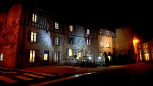 A historic building with multiple windows and a prominent circular sign. - Le Saint Eloi (Solignac)