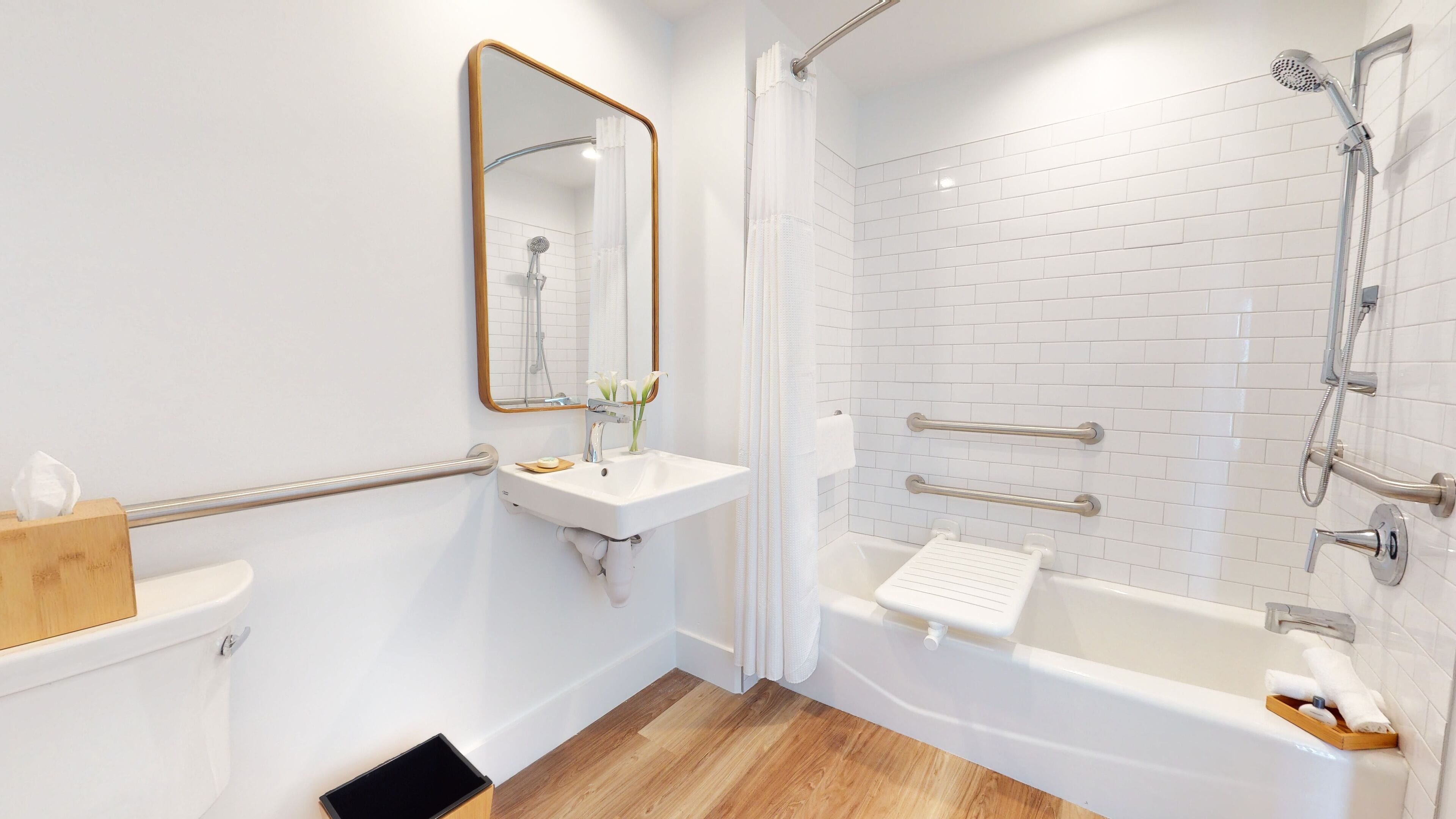 A modern bathroom with a white sink, mirror, and shower.