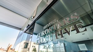Une façade d’hôtel moderne sur laquelle on peut lire en grand le nom « HOTEL EUROSTAR EXECUTIVE ».
