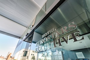 Fachada moderna de un hotel con el nombre "HOTEL EUROSTAR EXECUTIVE" claramente visible.