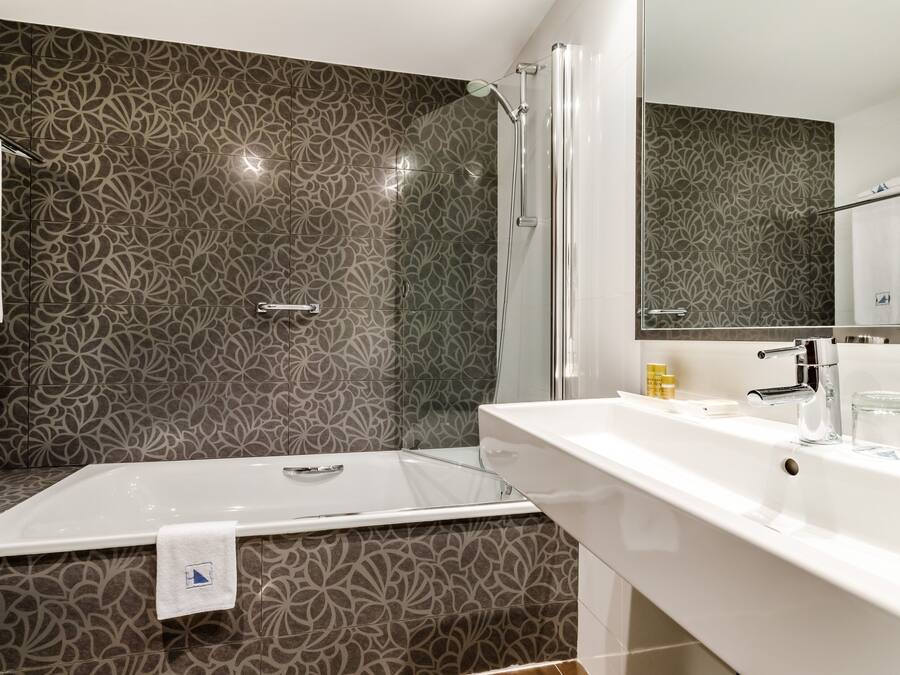 Une salle de bain moderne équipée d’une douche, d’une baignoire et d’un lavabo.