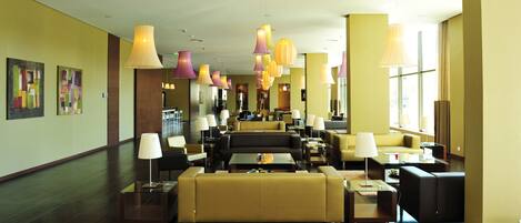 A hotel lobby with multiple seating areas, including sofas and chairs, arranged in a spacious layout.