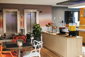 A modern hotel lobby with a reception desk, seating area, and elevators. - Aera São José Floripa (Sao Jose)