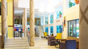 A spacious lobby with a staircase, seating area, and a view of the interior.