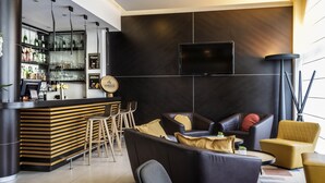 A modern bar area with a counter, stools, and a television mounted on the wall. - Novotel Brussels Centre Midi Station (Brussels)