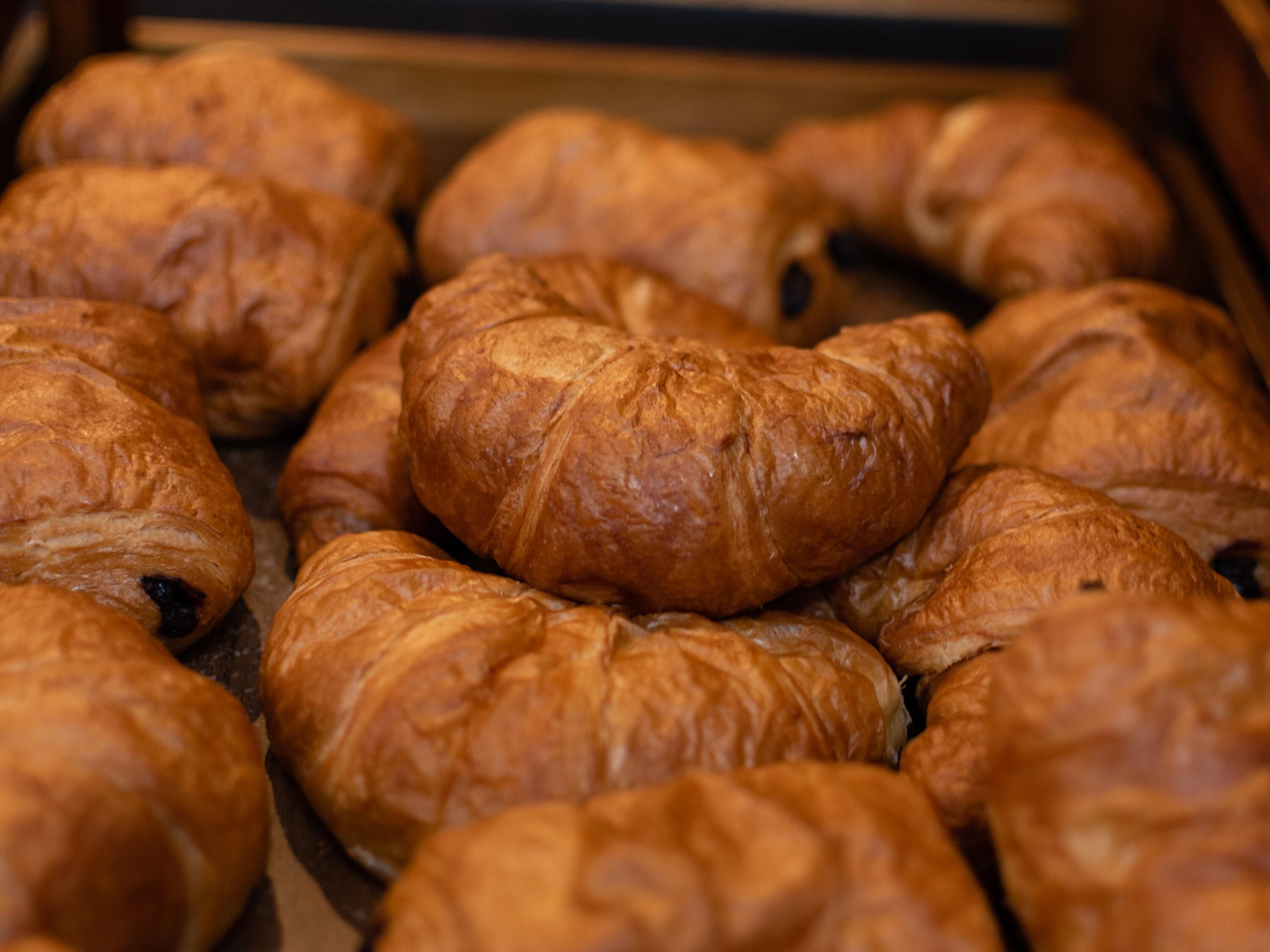 Uma bandeja com diversos doces, incluindo croissants e recheados com chocolate.