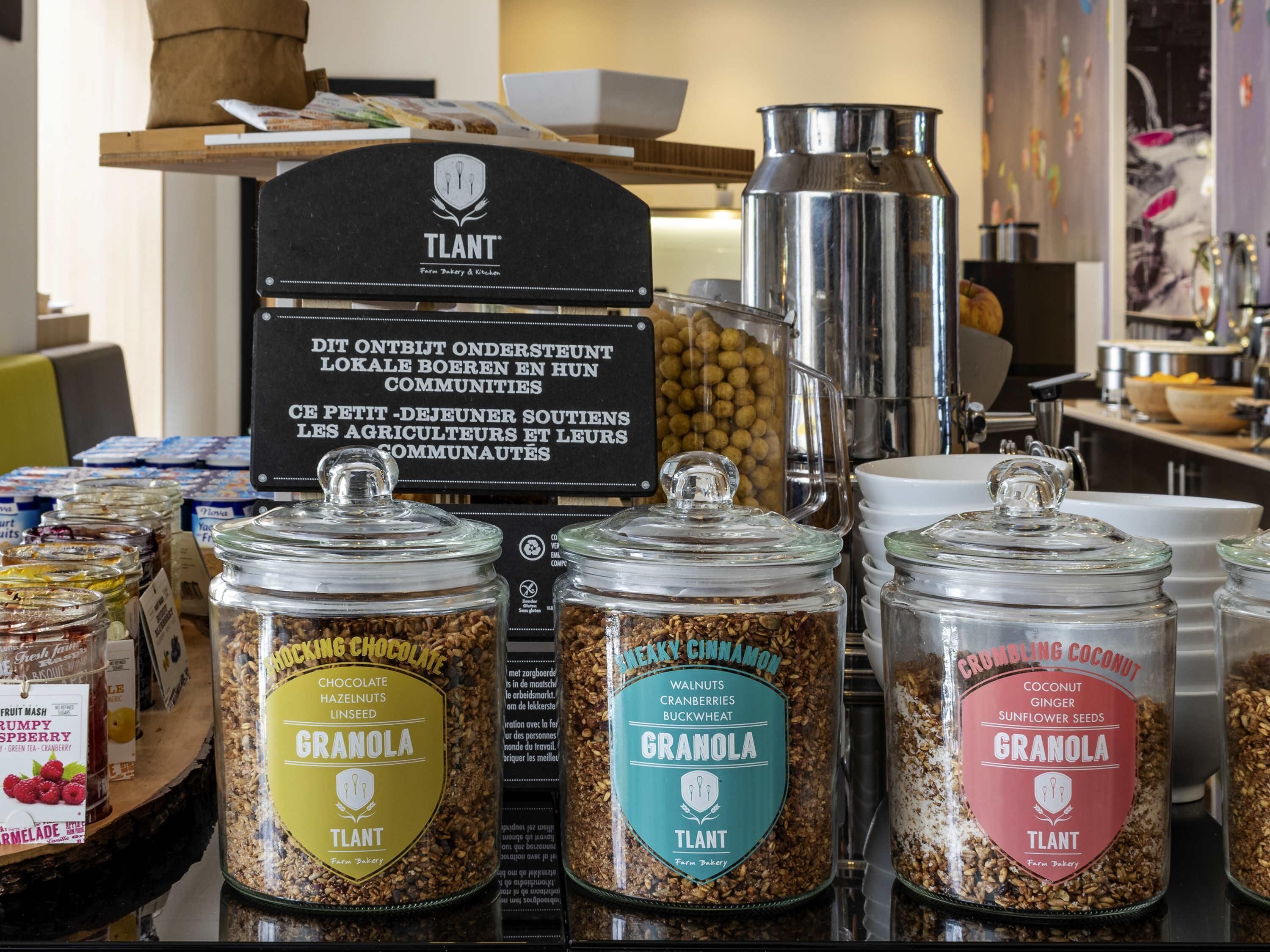 A display of granola jars with labels, a coffee machine, and a sign in the background.