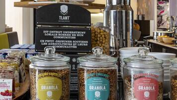 A display of granola jars with labels, a coffee machine, and a sign in the background.