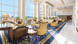 A spacious lobby with high ceilings, large windows, and elegant chandeliers. - The Regency Hotel, Kuwait (Salmiya)