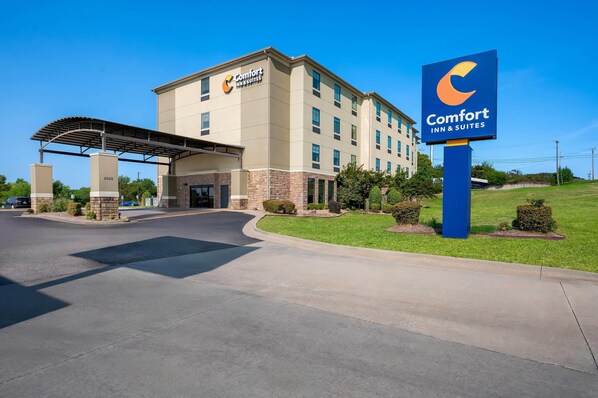 Un hotel Comfort Inn & Suites con entrada cubierta, estacionamiento y jardines bien cuidados.