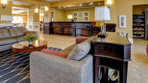 A hotel lobby with a reception desk, sofas, and a coffee table. - Comfort Inn & Suites Fort Smith I-540 (Fort Smith)