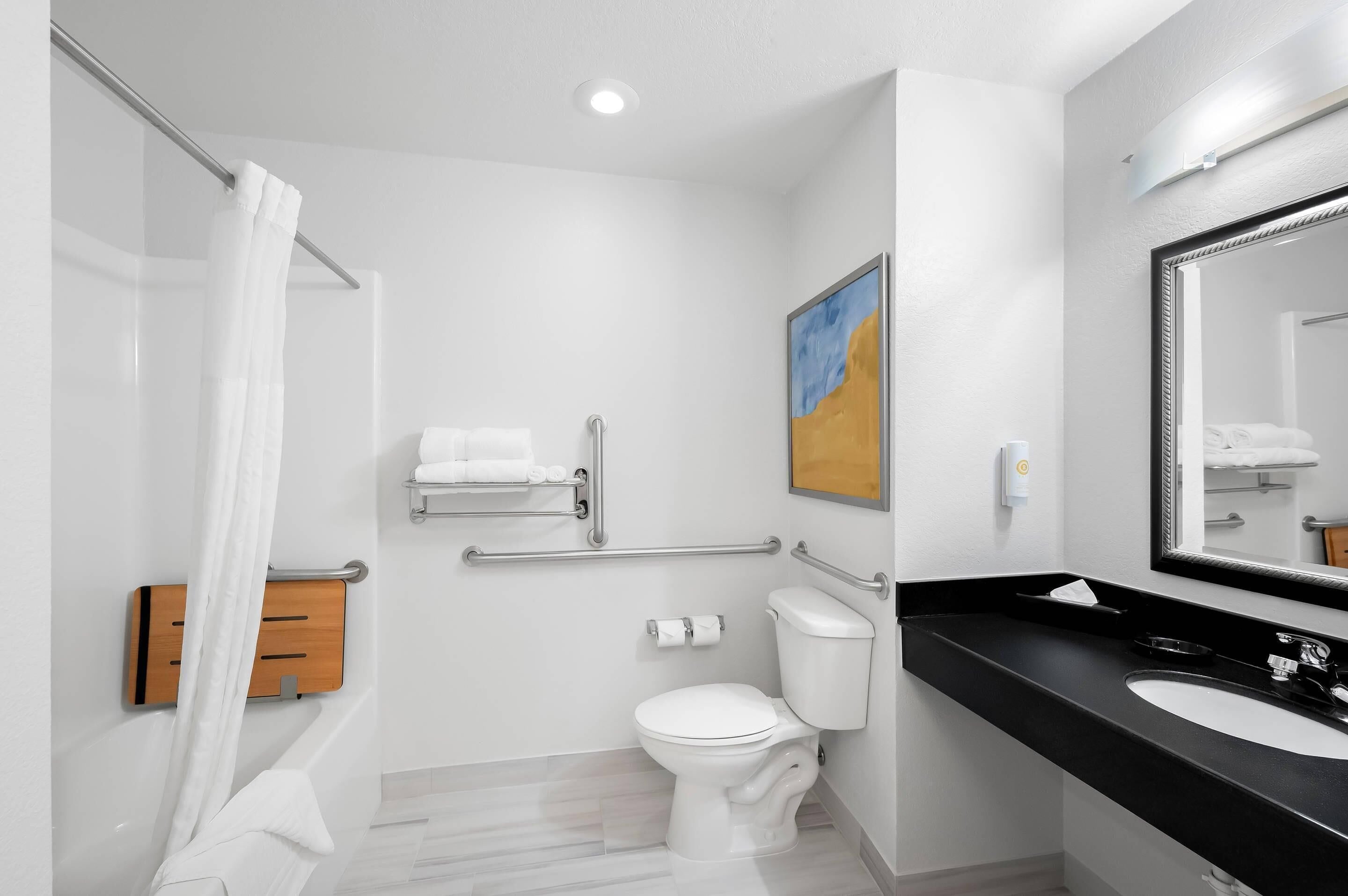 A modern bathroom with a white toilet, a black sink, and a shower with a white curtain.