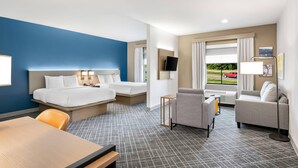 A hotel room with a bed, two sofas, a table, and a TV. - Comfort Inn & Suites Fort Smith I-540 (Fort Smith)