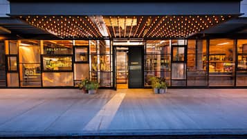 A hotel entrance with a reception area, a bar, and a coffee shop.